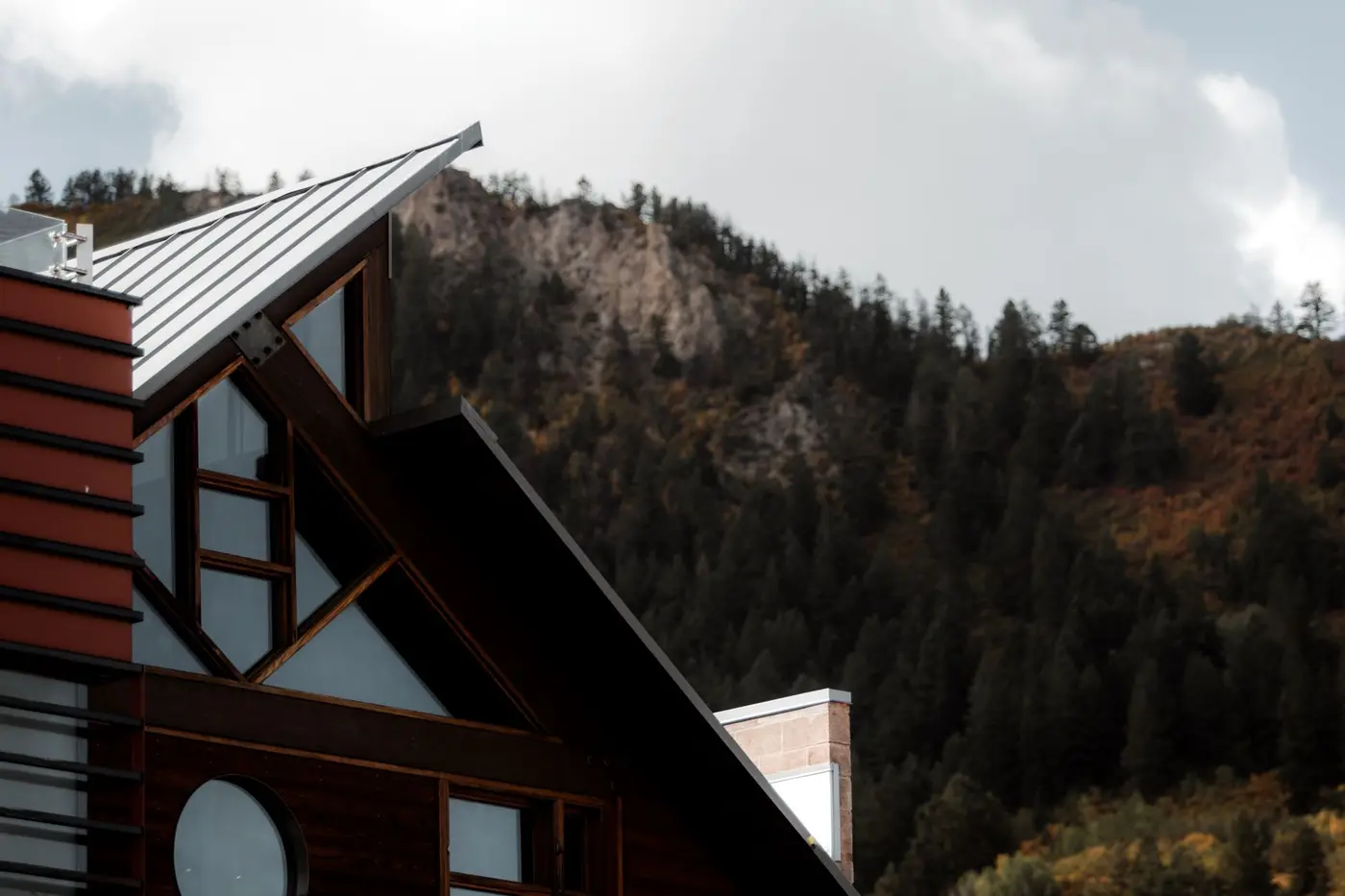 A standing seam metal roof on a modern timber house, the raised seams running the full length of each slope